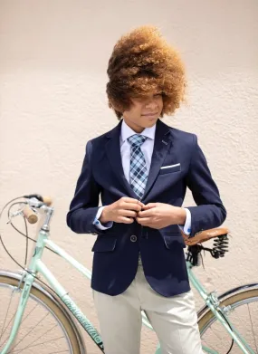 Comunión niño elegante con chaqueta azul marino, camisa y chino de traje color beige con corbata